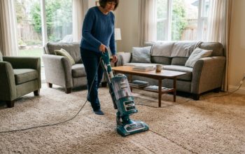 Shark upright vacuum cleaning a carpeted living room floor